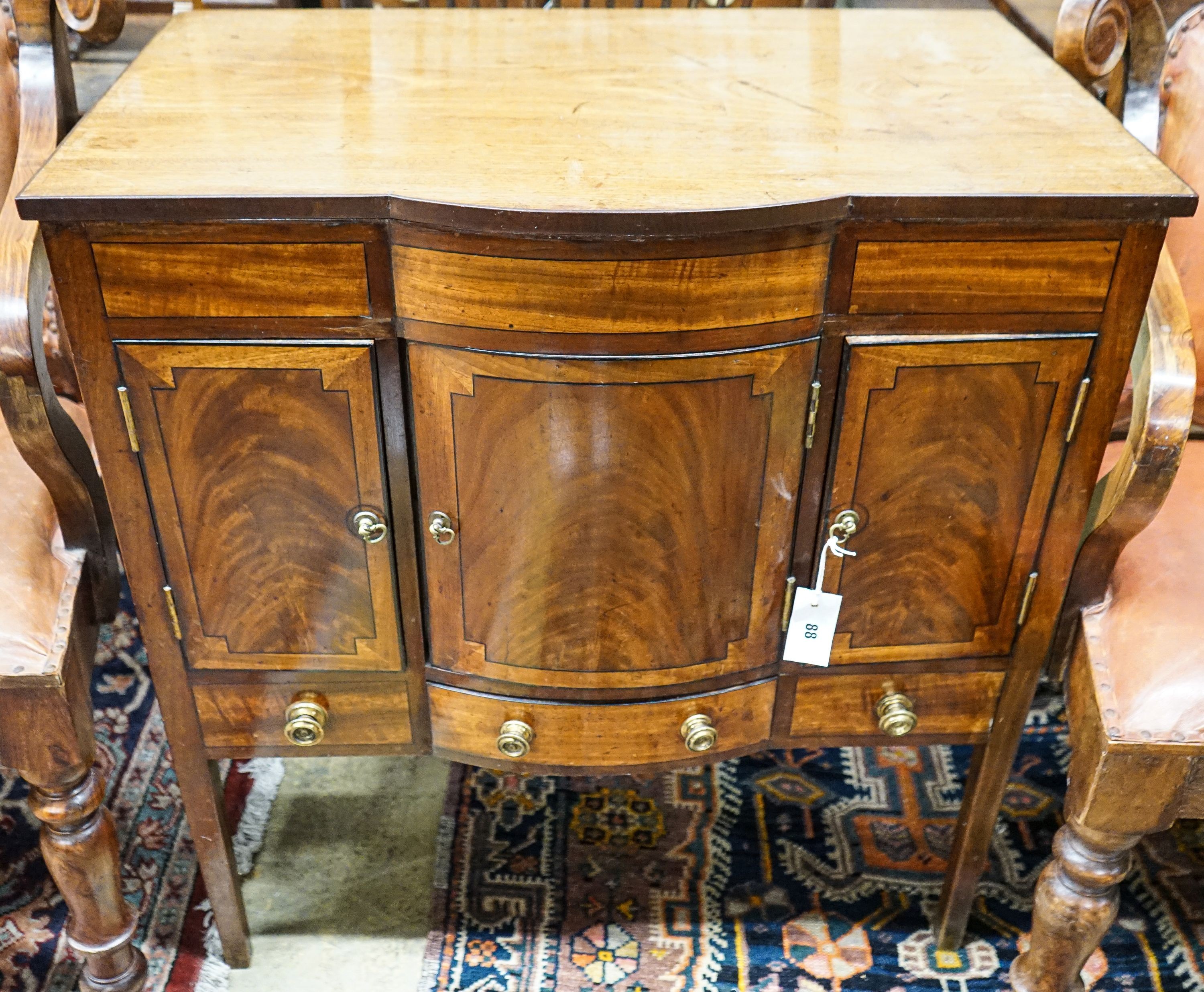 An Edwardian ebony strung mahogany bow front hinged top cabinet, width 77cm, depth 49cm, height 82cm